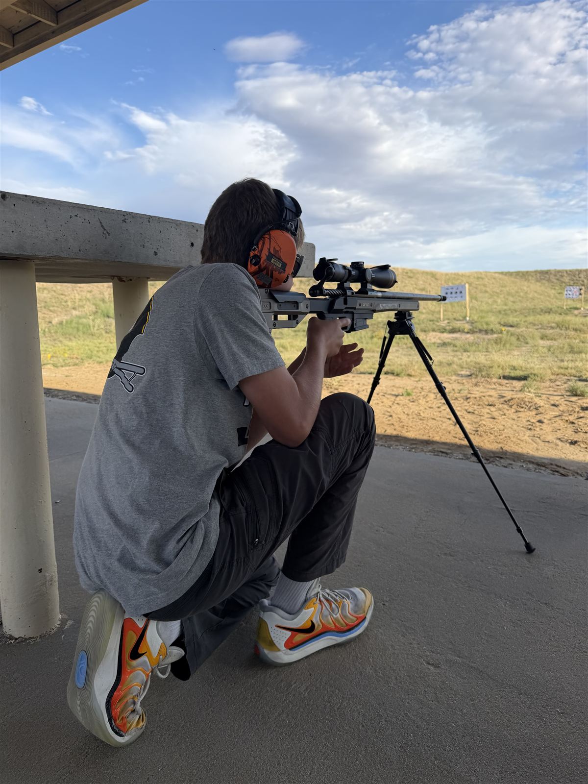 Chase practicing from a supported kneeling position at the range